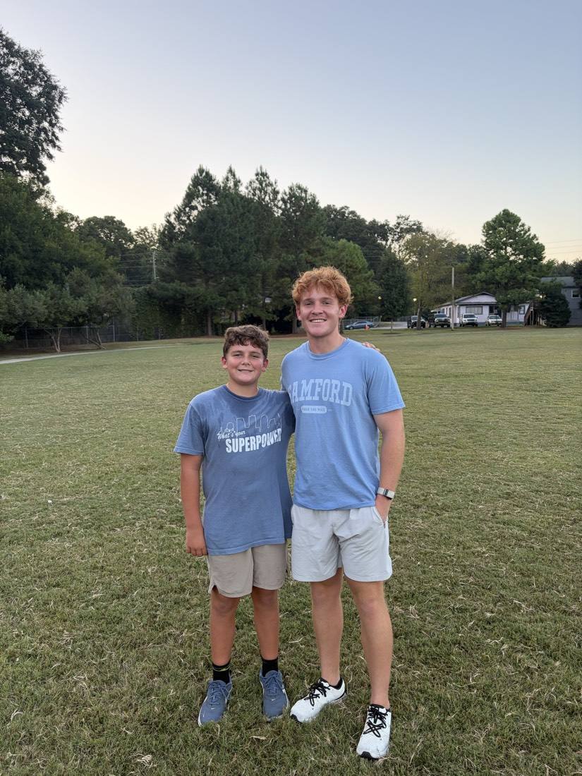 A 55 Athletics coach and a young athlete on the practice field