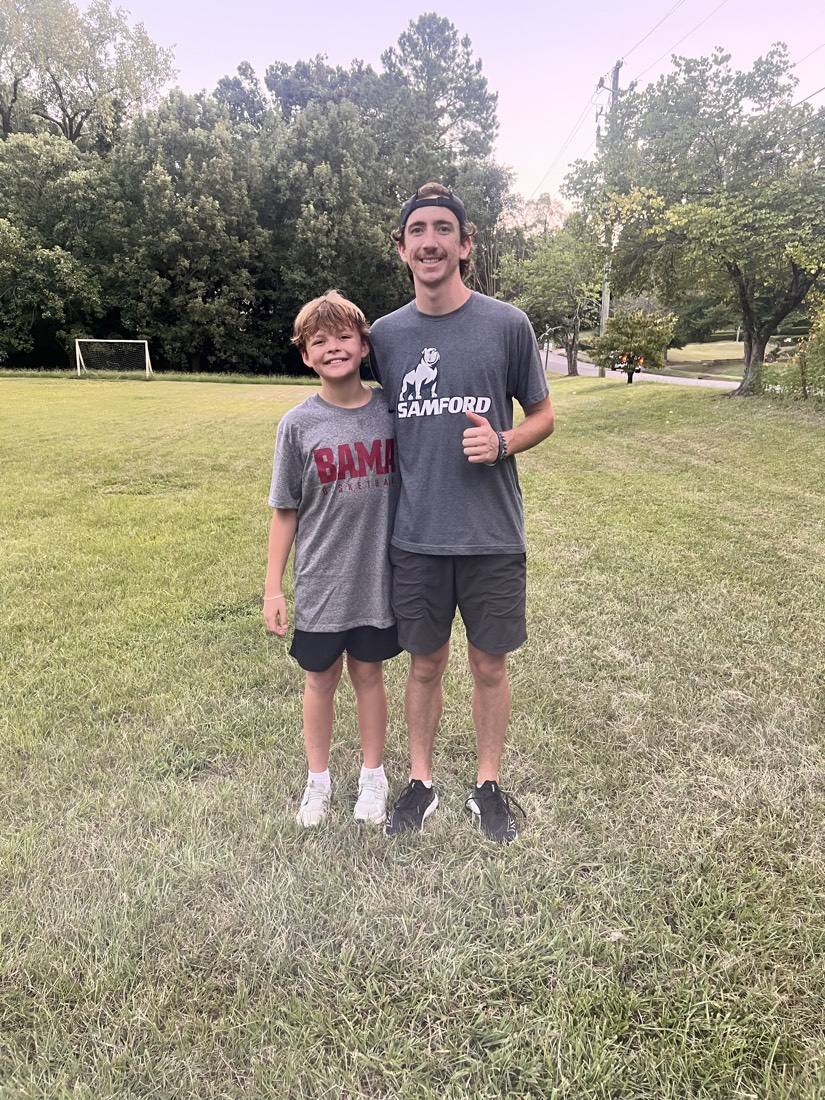 A coach and a young athlete giving a thumbs up after training