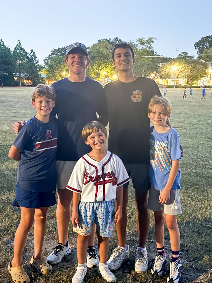 Two 55 Athletics coaches with three young athletes at the park