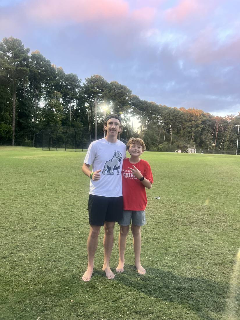 A 55 Athletics coach and a young athlete at sunset
